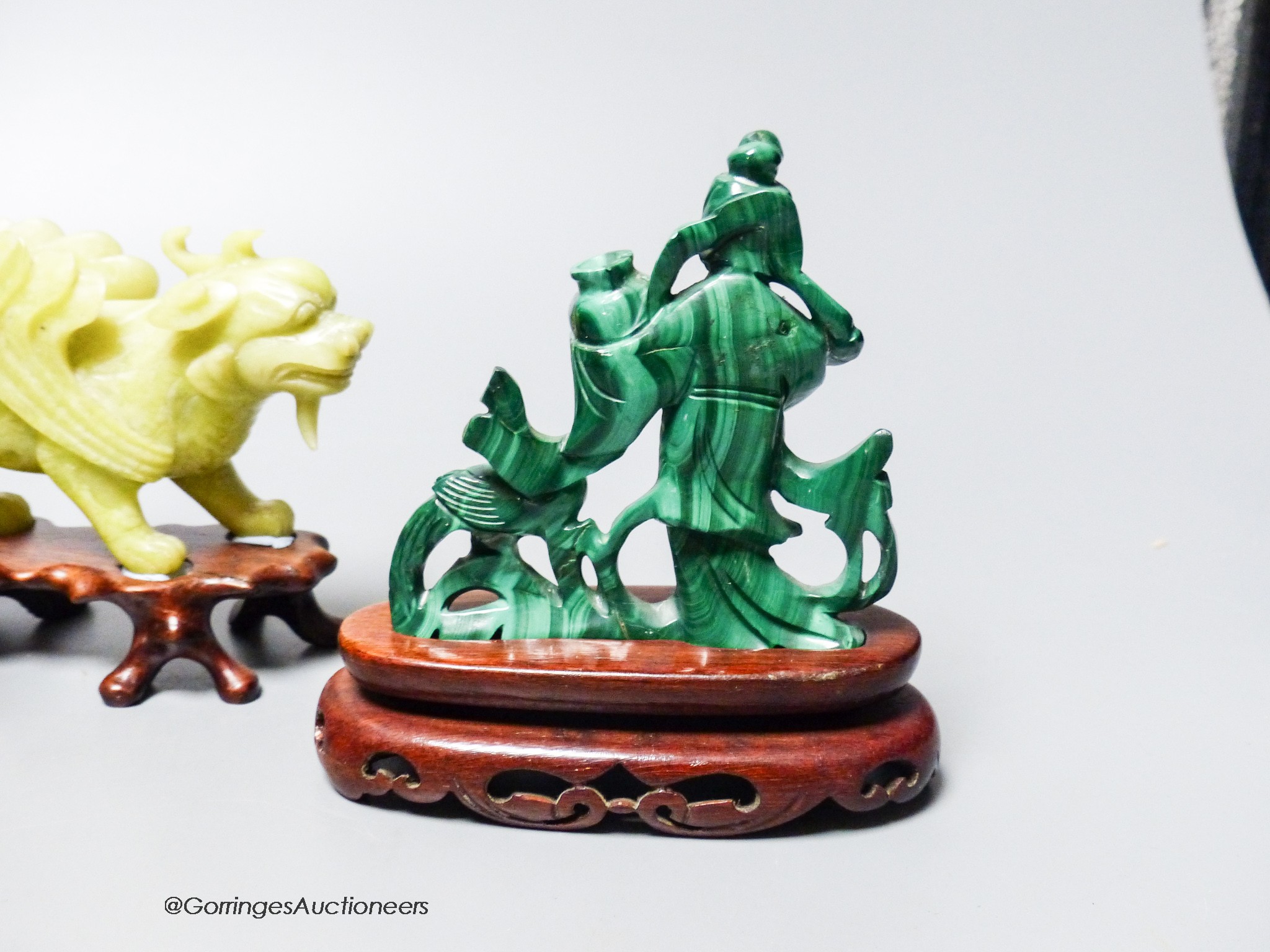 A group of Chinese hardstone carvings, mid 20th century to include a pair of mythical beasts, a pair of bowenite jade figures of tiger prawns and a malachite figure of a lady, three wood stands